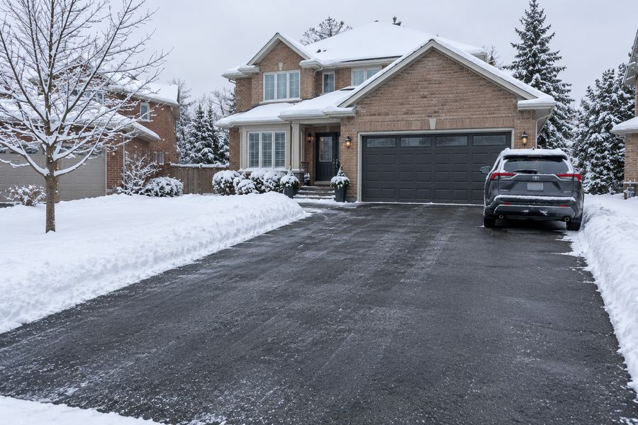 Residential driveway cleared of snow with neat snowbanks along both sides