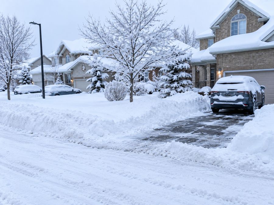 Suburban street and driveway after a heavy snowfall with a cleared driveway